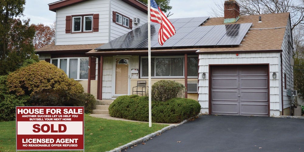 house with solar with sold sign out front