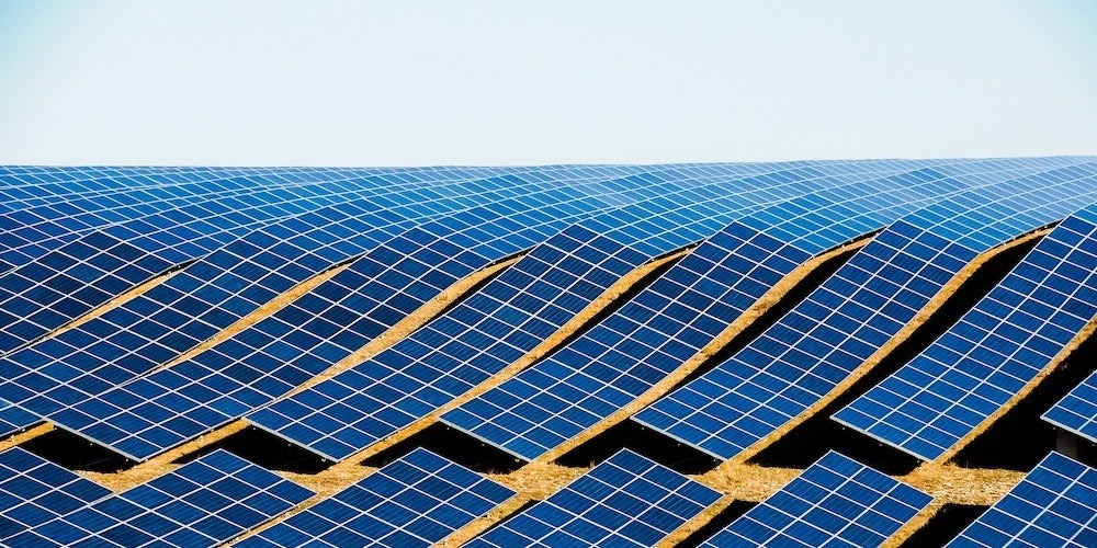 A large solar panel array on a rolling hillside